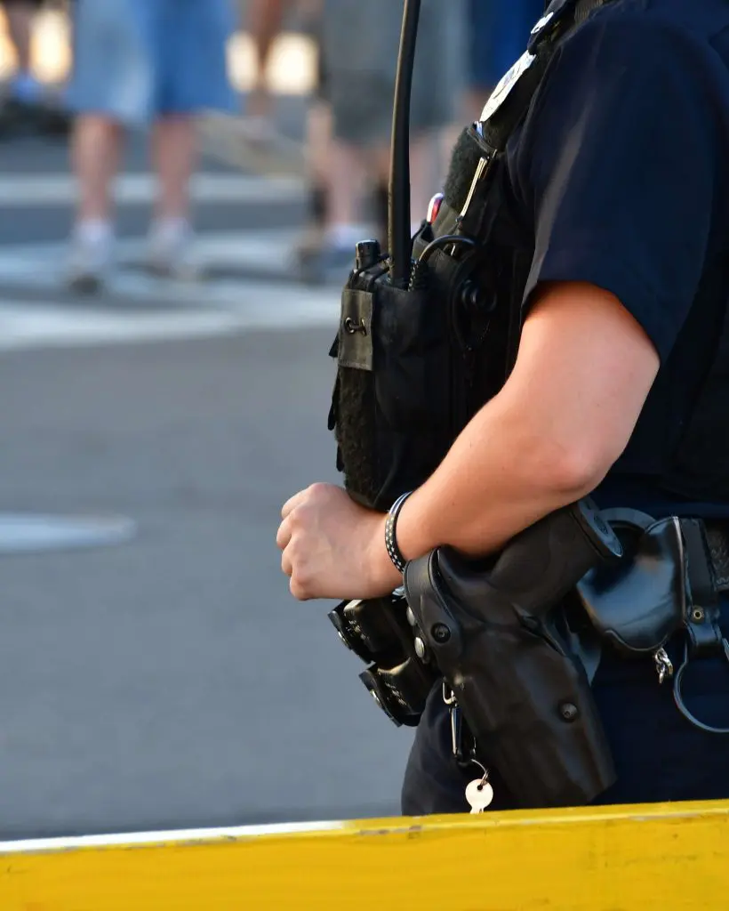 Female police officer standing guard behind a barricade. police officers, law enforcement
